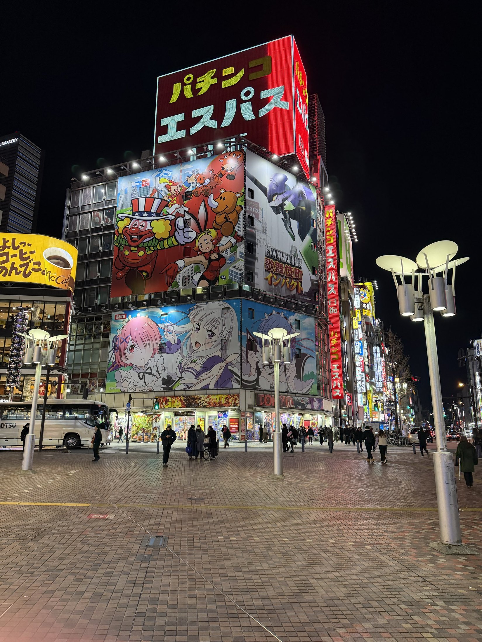 Quartier de Tokyo illuminé la nuit, avec des passants sous les enseignes japonaises