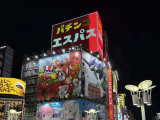 Quartier de Tokyo illuminé la nuit, avec des passants sous les enseignes japonaises