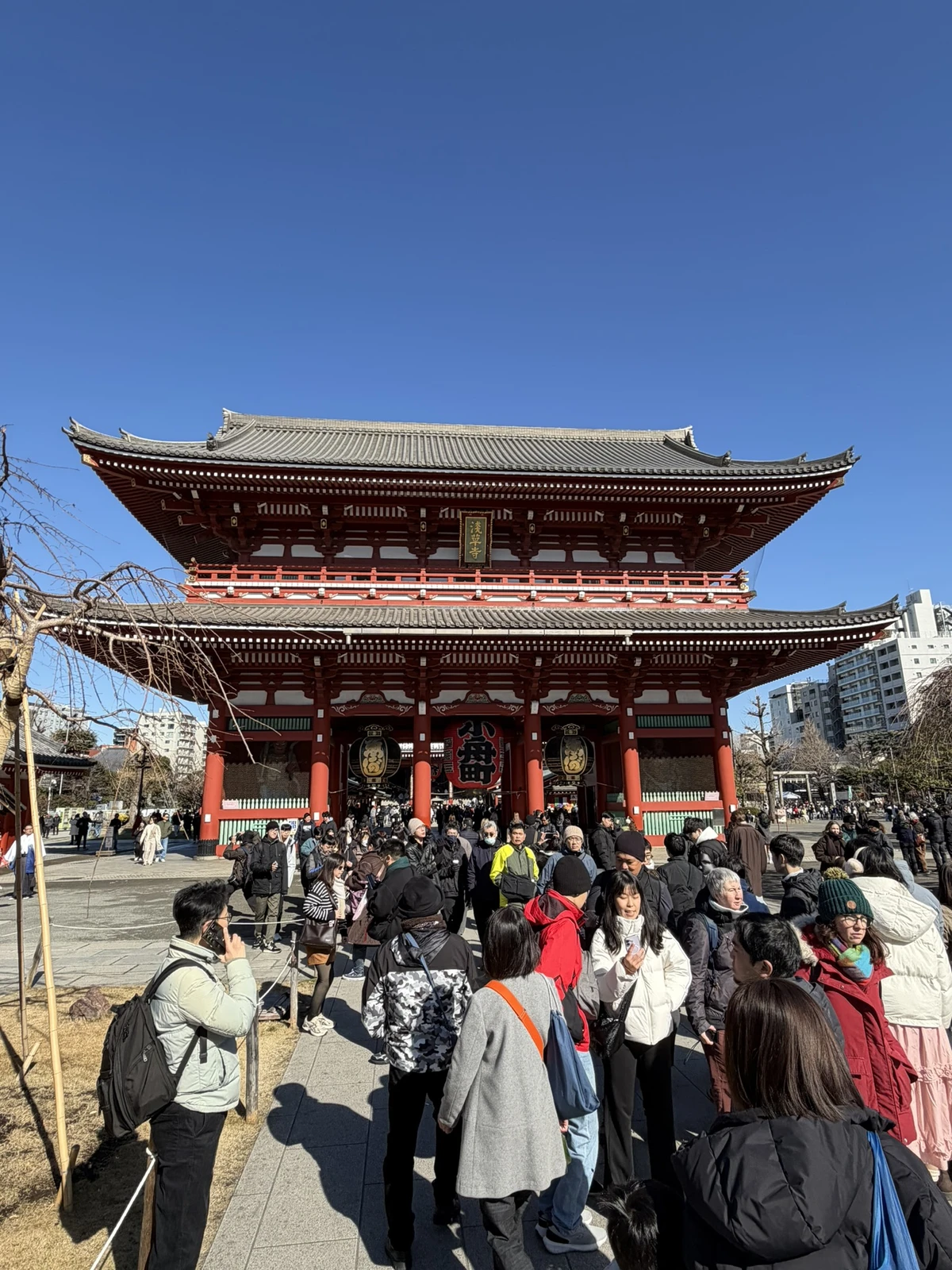 Porte monumentale rouge du Sensō-ji à Asakusa, avec les visiteurs sur l’esplanade.